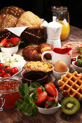 Obraz na płótnie Canvas Breakfast served with coffee, orange juice, croissants and strawberry, jam and tea. breakfast table