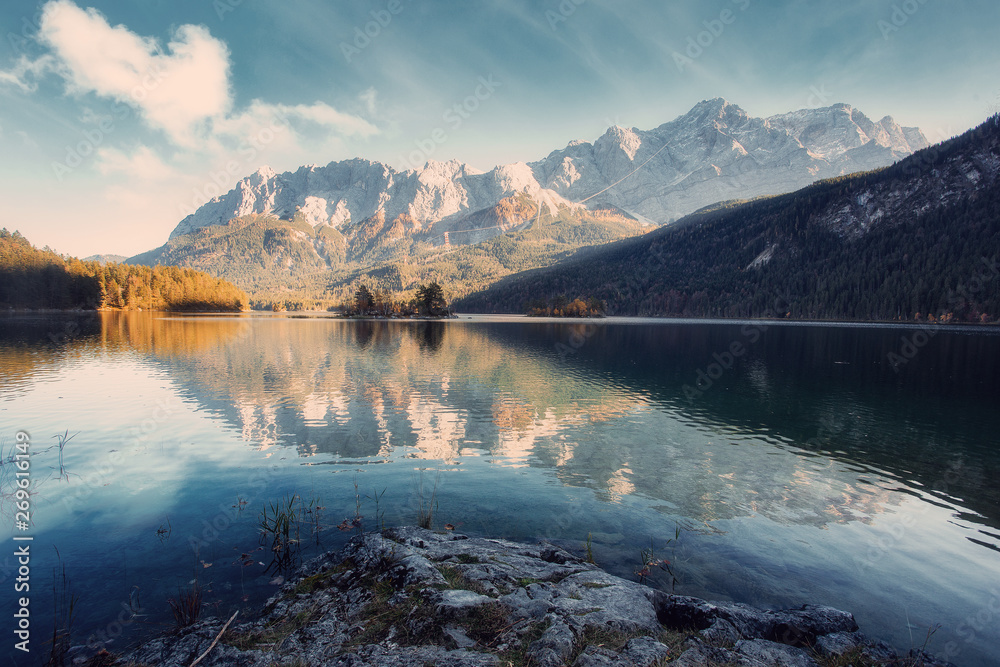 Aufkleber Impressive Autumn landscape The Eibsee Lake in front of the Zugspitze under sunlight. Amazing sunny day on the mountain lake. concept of an ideal resting place. Eibsee lake in Bavaria, Germany