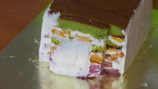 Lubricate the biscuit cake with multi-colored cake layers with butter cream
