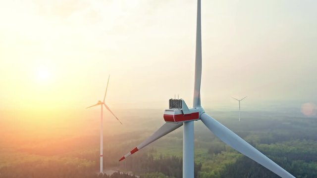 AERIAL 4K / Ultra HD - Birds eye view on Wind Power, Turbine, Windmill, Energy Production at sunrise - Clean and Renewable Energy 