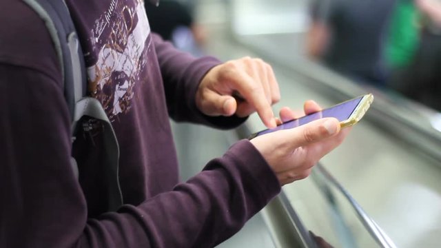 Man using smart phone on escalator
