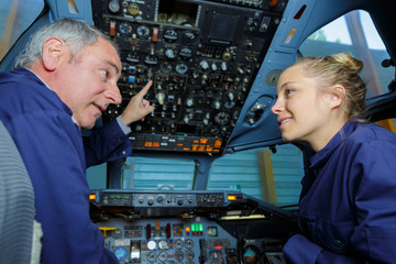 apprentice engineer in stationary aircraft cockpit with supervisor © auremar