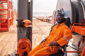 happy Seaman AB or Bosun on deck of vessel or ship , wearing PPE personal protective equipment -...