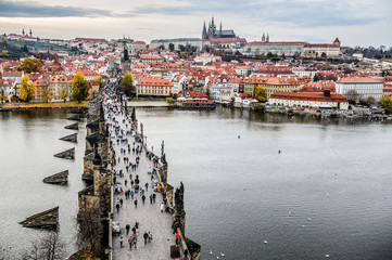 Tourists at Prague Charles Bridge. Prague with Vltava river. Cityscape with mass tourism