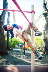 little cute blond boy hanging on playground outside, alone training with fun, lifestyle children concept 