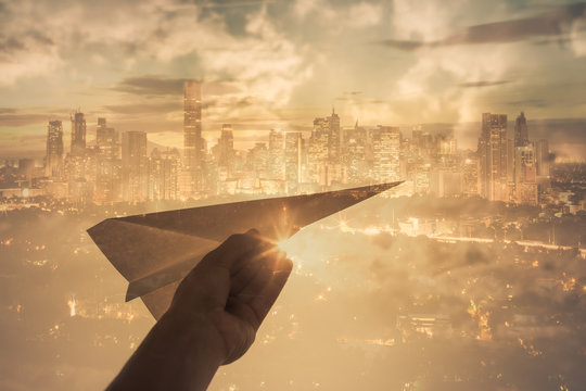 Hand Holding Paper Airplane In The Sky. Taking Off, Creativity Concept. 