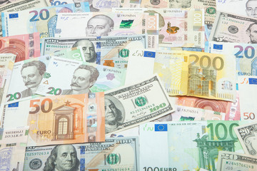 Money and finances concept. One hundred dollar new bill on colorful abstract background of Ukrainian, American and euro national currency banknotes