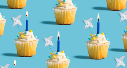 Tasty celebratory cupcakes with decorative lit candles
