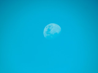 Crescent moon convex during the day. Blue sky.