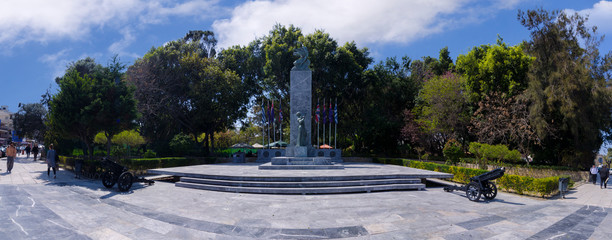 Heraklion, Crete Island / Greece. Monument of the Batlle of Crete (World War 2) at Georgiadi's park in the center of Heraklion city. Panoramic view on a sunny day with cloudy sky