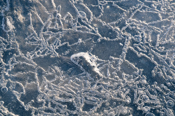 Texture abstract closeup background ice with grooves, furrows, and bubbles of air cought by frost in the mass of water while freezing