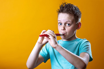 a boy in a light t-shirt playing on a pipe on a colored background