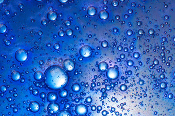 Naklejka na ściany i meble Blue background transparent slime with air bubbles