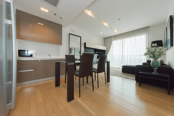 Wooden chairs at table in bright open space interior 