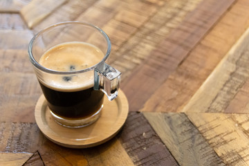Close-up of a glass cup of coffee on wooden table