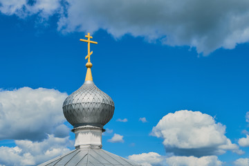 The dome of the Orthodox Church with cross against the blue sky