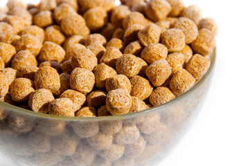 The concept of a healthy lifestyle, treatment of diseases and proper nutrition, nutrition and cleansing the body of toxins. Bowl with bran in the shape of balls, white background close-up. Copyspace.