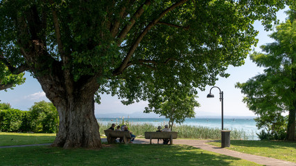 Couples relaxing and admiring a beautiful lake view, Lake Garda, Italy