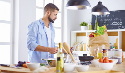 Smiling and confident chef standing in large kitchen