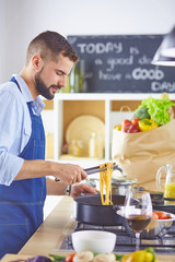 Smiling and confident chef standing in large kitchen