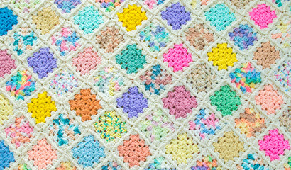 background texture -full frame wide view of a colorful hand knitted pastel afghan blanket