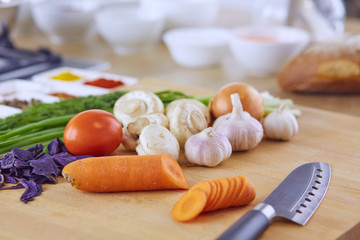 Composition with wooden board and ingredients for cooking on table