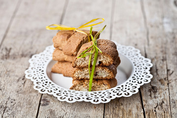 Fresh Italian cookies cantuccini on white plate on ructic wooden table background.