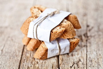 Traditional Italian cookies cantuccini on white paper on ructic wooden table background.
