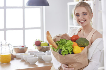 Young woman holding grocery shopping bag with vegetables Standi
