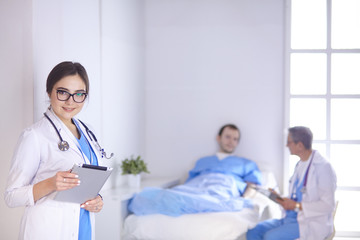 Doctor checking heart beat of patient in bed with stethoscope