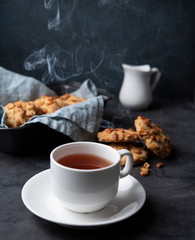 white cup of tea with water stream cookies handmade close up