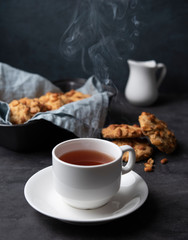 white cup of tea with water stream cookies handmade close up