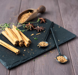 cinnamon stisk and powder on the wood brown table anise stars rustic close up spicy