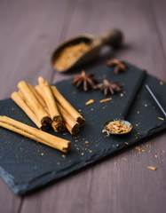 cinnamon stisk and powder on the wood brown table anise stars rustic close up spicy