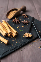 cinnamon stisk and powder on the wood brown table anise stars rustic close up spicy