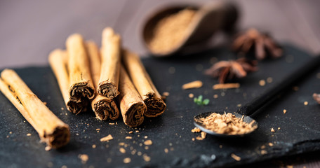 cinnamon stisk and powder on the wood brown table anise stars rustic close up spicy