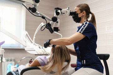 Doctor making teeth examination research survey using microscope in dentistry. Dentist is treating...