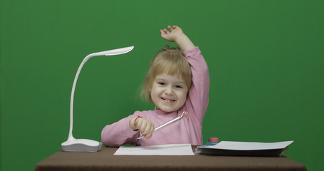 Girl at the table. Raises her hand because she knows the answer to the question