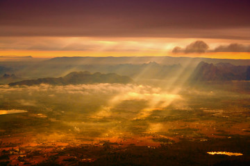 Colorful sunrise images sunbeams shine from sky through the land and mountain area background