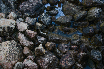 Rock background, top view on wild stone beach 