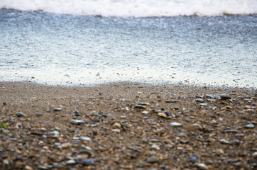 Background of seashore, pebble beach and sea close up