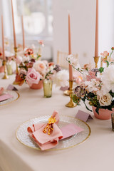 Wedding decoration table in the hall, floral arrangement. In the style vintage. Decorated dining table with flowers for guests and newlyweds, in peach-pink & pastel color. Beautiful table setting.