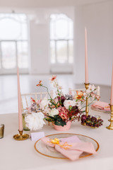 Wedding decoration table in the hall, floral arrangement. In the style vintage. Decorated dining table with flowers for guests and newlyweds, in peach-pink & pastel color. Beautiful table setting.