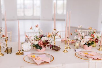 Wedding decoration table in the hall, floral arrangement. In the style vintage. Decorated dining table with flowers for guests and newlyweds, in peach-pink & pastel color. Beautiful table setting.