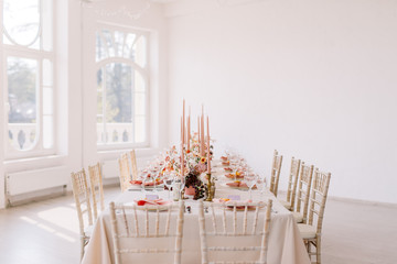 Wedding decoration table in the hall, floral arrangement. In the style vintage. Decorated dining table with flowers for guests and newlyweds, in peach-pink & pastel color. Beautiful table setting.