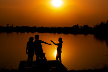 Fototapeta na wymiar Love of three people at reservoir and View Reservoir In the evening and Sunset