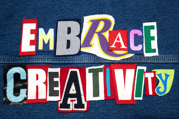 Bright EMBRACE CREATIVITY word collage from cut tee shirt letters on denim, personal growth, horizontal aspect