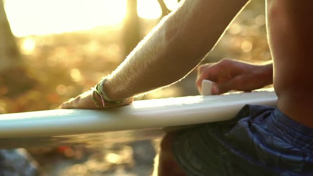  surfer guy waxing surfboard on beach at sunset. Healthy Active Lifestyle. Surfing. Summer Vacation. 