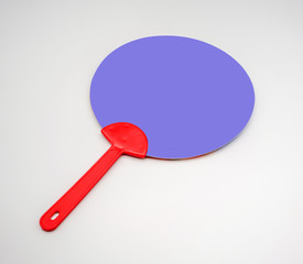 Hand holding red and blue plastic fan isolated on white