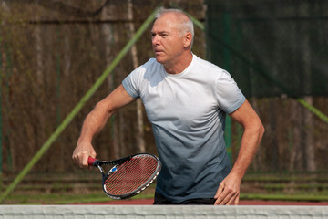 Man playing tennis on the outdoor court